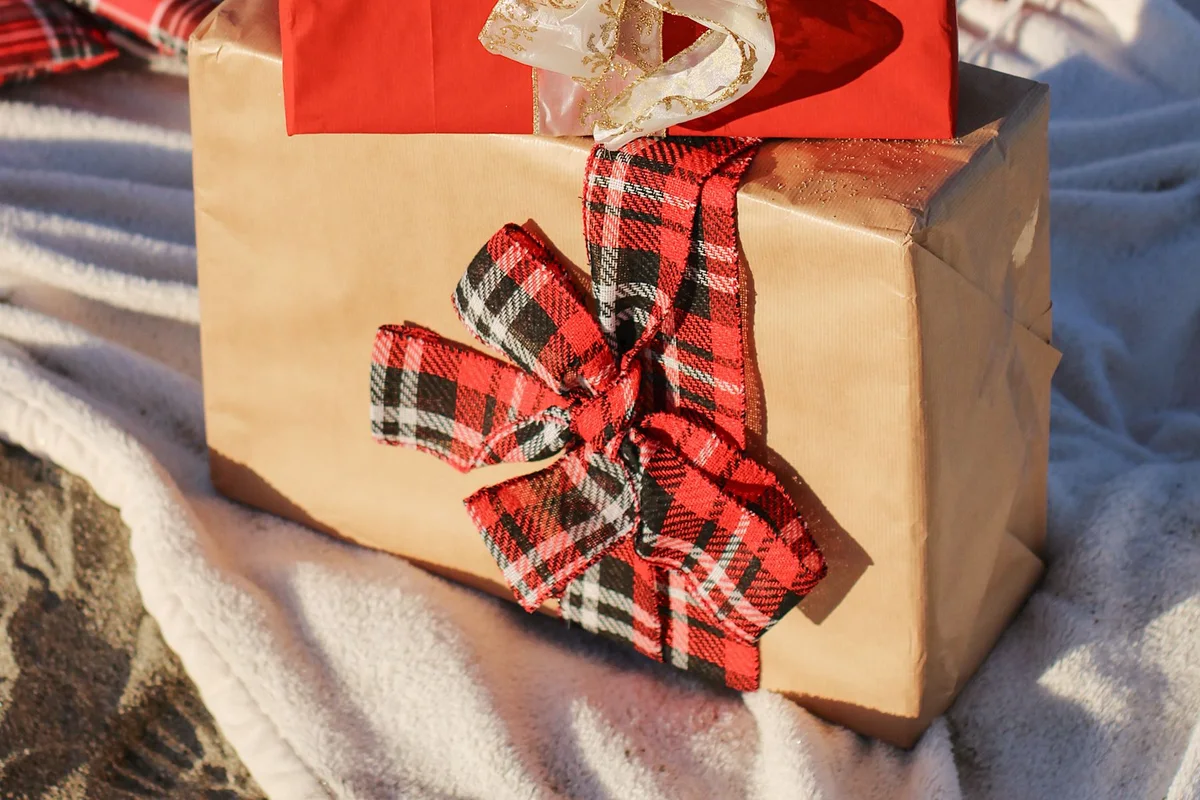 Christmas presents wrapped in gold and red paper with patterned ribbons